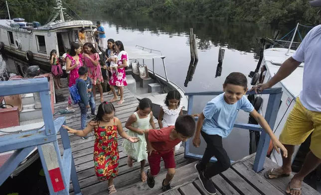 Children arrive at the Emilio Goeldi Museum's scientific station in the Caxiuana National Forest in Para state, Brazil, Friday, March 21, 2025. (AP Photo/Jorge Saenz)