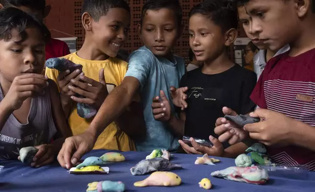 Children make manatee models out of Play-Doh during a trip to Emilio Goeldi Museum's scientific station in Para state, Brazil, Friday, March 21, 2025. (AP Photo/Jorge Saenz)
