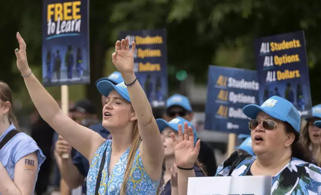 Pamela Smith of Sterling, Va., left, and Tammy-Kay Williams of Fountain Hills, Ariz., right, react as supporters of charter schools rally outside of the Supreme Court on Wednesday, April 30, 2025, in Washington. (AP Photo/Mark Schiefelbein)