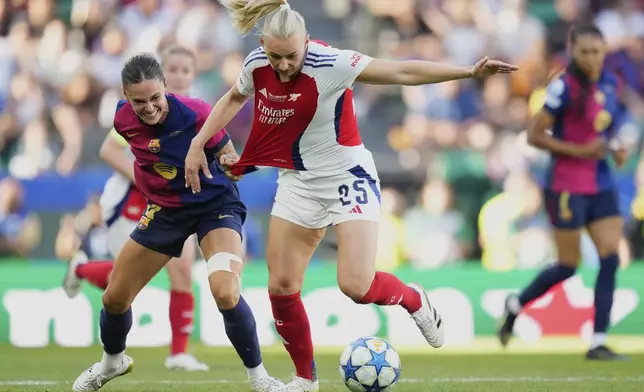 Arsenal's Stina Blackstenius, center, duels for the ball with Barcelona's Mapi Leon during the women's Champions League final soccer match between Arsenal and FC Barcelona at the Jose Alvalade Stadium in Lisbon, Saturday, May 24, 2025. (AP Photo/Jose Breton)