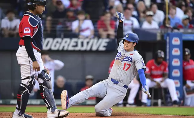 Los Angeles Dodgers' Shohei Ohtani (17) scores on an RBI single by Teoscar Hernandez (not shown) during the fifth inning of a baseball game against the Cleveland Guardians, Monday, May 26, 2025, in Cleveland. (AP Photo/David Dermer)