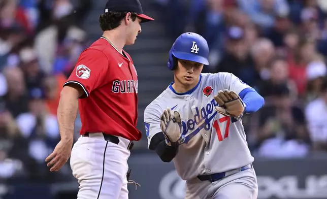 Los Angeles Dodgers' Shohei Ohtani (17) reacts after scoring on an RBI single by Freddie Freeman during the sixth inning of a baseball game against the Cleveland Guardians, Monday, May 26, 2025, in Cleveland. (AP Photo/David Dermer)