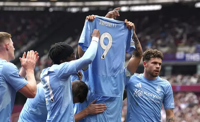 Nottingham Forest's Morgan Gibbs-White celebrates scoring their side's first goal of the game, holding a tribute to teammate Taiwo Awoniyi, during the English Premier League soccer match between Nottingham Forest and West Ham at London Stadium, London, Sunday, May 18, 2025. (Gareth Fuller/PA via AP)