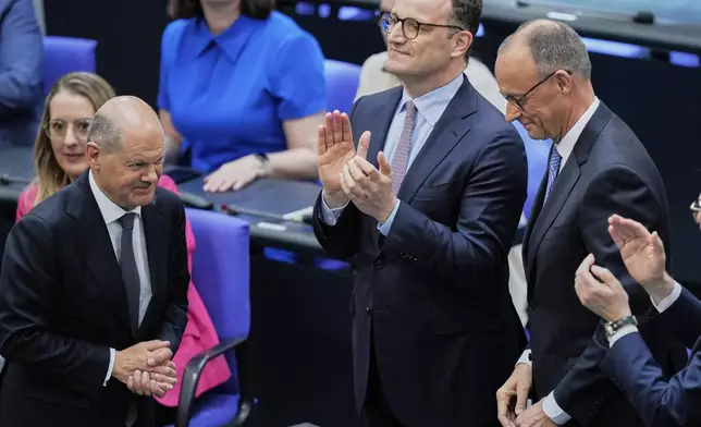 Leader of the Christian Democrats Friedrich Merz is congratulated by outgoing Chancellor Olaf Scholz after being elected new chancellor at the German federal parliament, Bundestag, at the Reichstag building in Berlin, Germany, Tuesday, May 6, 2025. (AP Photo/Ebrahim Noroozi)
