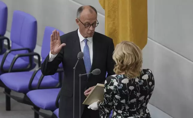 Friedrich Merz takes the oath of office in front of Parliament President Julia Kloeckner after being elected new Chancellor at the German federal parliament, Bundestag, at the Reichstag building in Berlin, Germany, Tuesday, May 6, 2025. (AP Photo/Markus Schreiber)