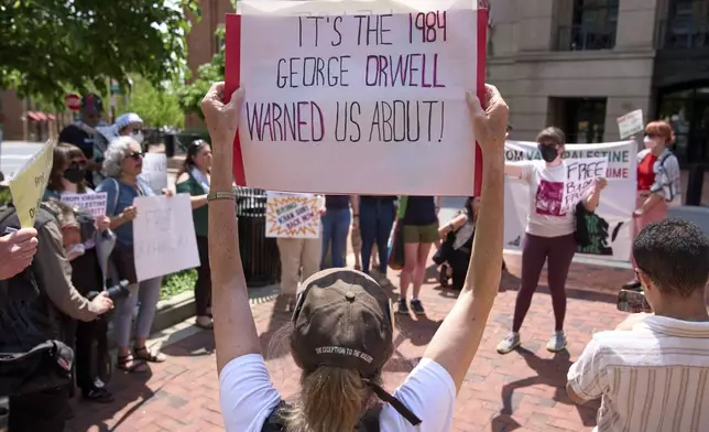 A supporter of Badar Khan Suri holds a sign saying "It's the 1984 George Orwell Warned Us About!," while attending a rally in opposition to the Georgetown University scholar's arrest and detention, outside of the courthouse, at the Federal District Court for the Eastern District of Virginia, in Alexandria, Va., Thursday, May 1, 2025. (AP Photo/Jacquelyn Martin)