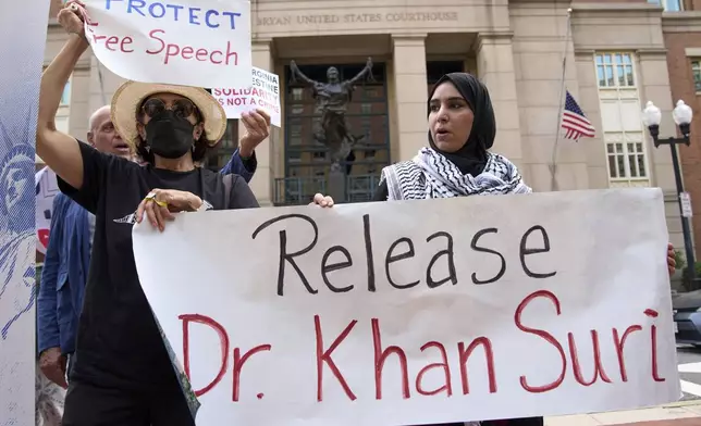 Mapheze Saleh, right, wife of arrested and detained Georgetown University scholar Badar Khan Suri, holds a sign calling for her husband's release after speaking at a news conference following his hearing at Federal District Court for the Eastern District of Virginia, in Alexandria, Va., Thursday, May 1, 2025. (AP Photo/Jacquelyn Martin)