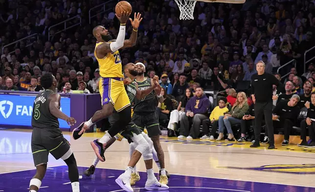 Los Angeles Lakers forward LeBron James (23) shoots as Minnesota Timberwolves guard Anthony Edwards (5), center Rudy Gobert (27) and guard Nickeil Alexander-Walker (9) defend during the second half in Game 5 of an NBA basketball first-round playoff series Wednesday, April 30, 2025, in Los Angeles. (AP Photo/Mark J. Terrill)