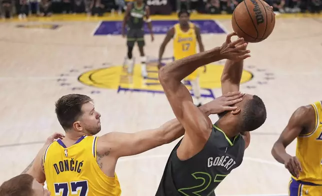 Minnesota Timberwolves center Rudy Gobert, right, is hit in the face by Los Angeles Lakers guard Luka Doncic as he grabs a rebound during the first half in Game 5 of an NBA basketball first-round playoff series Wednesday, April 30, 2025, in Los Angeles. (AP Photo/Mark J. Terrill)