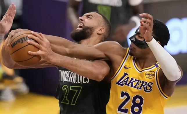 Minnesota Timberwolves center Rudy Gobert, left grabs a rebound next to Los Angeles Lakers forward Rui Hachimura (28) during the first half in Game 5 of an NBA basketball first-round playoff series Wednesday, April 30, 2025, in Los Angeles. (AP Photo/Mark J. Terrill)