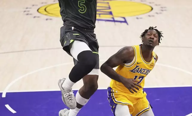 Minnesota Timberwolves guard Anthony Edwards, left, shoots as Los Angeles Lakers forward Dorian Finney-Smith defends during the first half in Game 5 of an NBA basketball first-round playoff series Wednesday, April 30, 2025, in Los Angeles. (AP Photo/Mark J. Terrill)