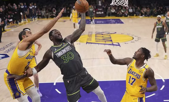 Minnesota Timberwolves forward Julius Randle, center, grabs a rebound away from Los Angeles Lakers guard Gabe Vincent, left, and forward Dorian Finney-Smith during the first half in Game 5 of an NBA basketball first-round playoff series Wednesday, April 30, 2025, in Los Angeles. (AP Photo/Mark J. Terrill)