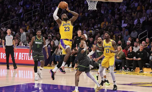 Los Angeles Lakers forward LeBron James (23) shoots as Minnesota Timberwolves guard Nickeil Alexander-Walker (9) defends during the first half in Game 5 of an NBA basketball first-round playoff series Wednesday, April 30, 2025, in Los Angeles. (AP Photo/Mark J. Terrill)