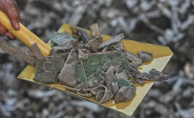 A Thai official shows samples of illegally imported electronic waste from the United States which they said they seized at Bangkok Port during a press conference in Bangkok, Thailand, Wednesday, May 14, 2025. (AP Photo/Sakchai Lalit)