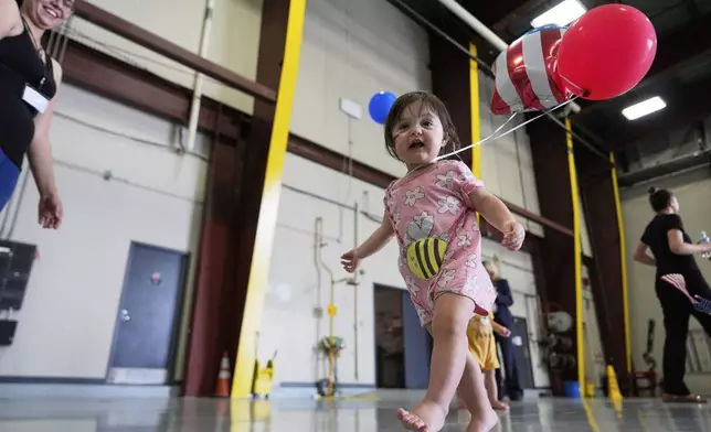 Young Afrikaner refugees from South Africa play with balloons as they arrive, Monday, May 12, 2025, at Dulles International Airport in Dulles, Va. (AP Photo/Julia Demaree Nikhinson)