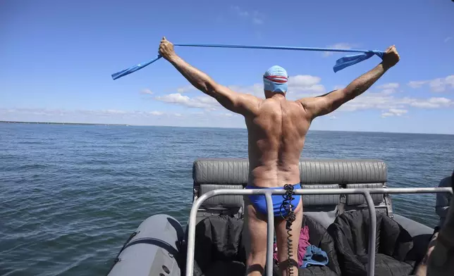 British South African endurance swimmer Lewis Pugh stretches before entering the water to complete his 12-day 62-mile (100 kilometer) swim around the island of Martha's Vineyard, Mass., ahead of the 50th anniversary of the first blockbuster film "Jaws"' release, Monday, May 26, 2025. (AP Photo/Leah Willingham)