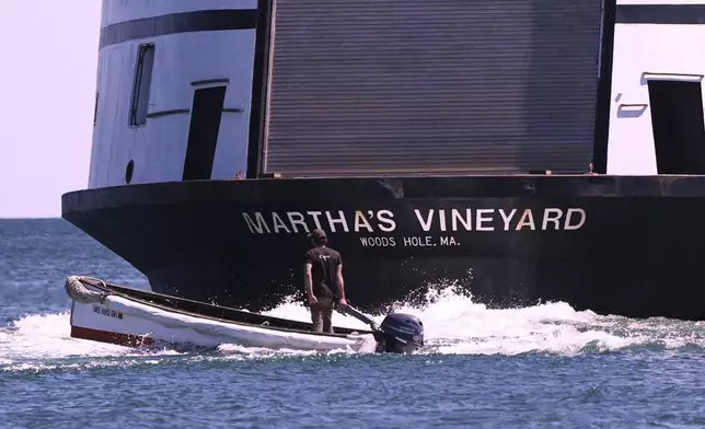 A man navigates the wake behind the Martha's Vineyard Ferry, Monday, May 12, 2025, in Vineyard Haven, Mass. (AP Photo/Charles Krupa)