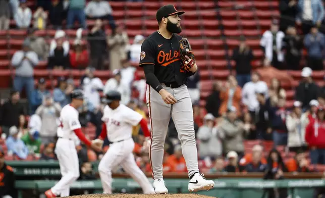 Baltimore Orioles third baseman Emmanuel Rivera, who pitched the eighth inning, stands on the mound as Boston Red Sox's Rafael Devers, second from back left, rounds the bases after hitting a grand slam in the first baseball game of a doubleheader Friday, May 23, 2025, at Fenway Park in Boston. (AP Photo/Winslow Townson)