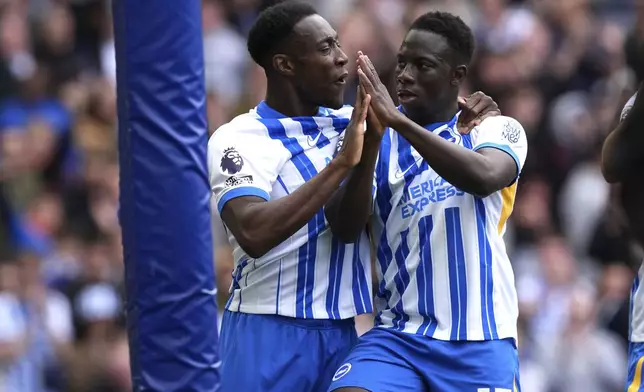 Brighton and Hove Albion's Yankuba Minteh, right, celebrates with Danny Welbeckduring after scoring the opening goal during the English Premier League soccer match between Brighton and Hove Albion and Newcastle United in Brighton and Hove, England, Sunday, May 4, 2025. (Gareth Fuller/PA via AP)