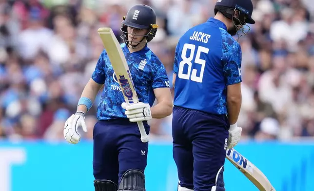 England's Jacob Bethell, left, celebrates a half century during the first One Day International match between England and West Indies at Edgbaston, Birmingham, England, Thursday May 29, 2025. (Nick Potts/PA via AP)