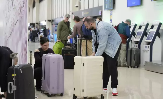 People prepare to board flights at Newark Liberty International Airport in Newark, N.J., Monday, May 5, 2025. (AP Photo/Seth Wenig)