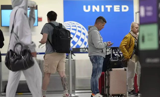 People prepare to board flights at Newark Liberty International Airport in Newark, N.J., Monday, May 5, 2025. (AP Photo/Seth Wenig)