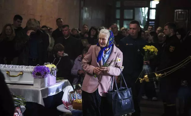 A woman cries during a funeral ceremony for Tamara Martyniuk, 8, Stanislav Martyniuk, 12, and Roman Martyniuk, 17, killed in a Russian strike on Sunday, in Korostyshiv, Zhytomyr region, Ukraine, Wednesday, May 28, 2025. (AP Photo/Evgeniy Maloletka)