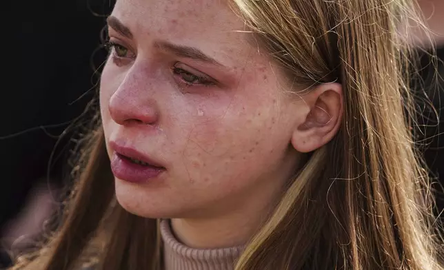 A woman cries during a funeral ceremony for Tamara Martyniuk, 8, Stanislav Martyniuk, 12, and Roman Martyniuk, 17, killed in a Russian strike on Sunday, in Korostyshiv, Zhytomyr region, Ukraine, Wednesday, May 28, 2025. (AP Photo/Evgeniy Maloletka)