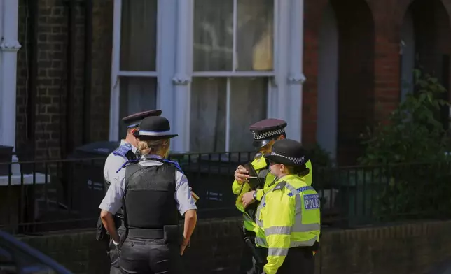 Police Community Support Officers and Police Officers stand on the street near a house belonging to British Prime Minister Keir Starmer at Kentish Town in London, Tuesday, May 13, 2025. (AP Photo/Kirsty Wigglesworth)
