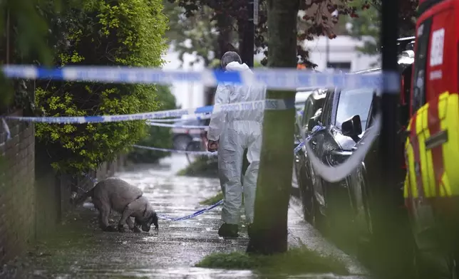 A forensics officer with a dog is seen in Kentish Town, near British Prime Minister Keir Starmer's house in north London, Monday, May 12, 2025. (James Manning/PA via AP)