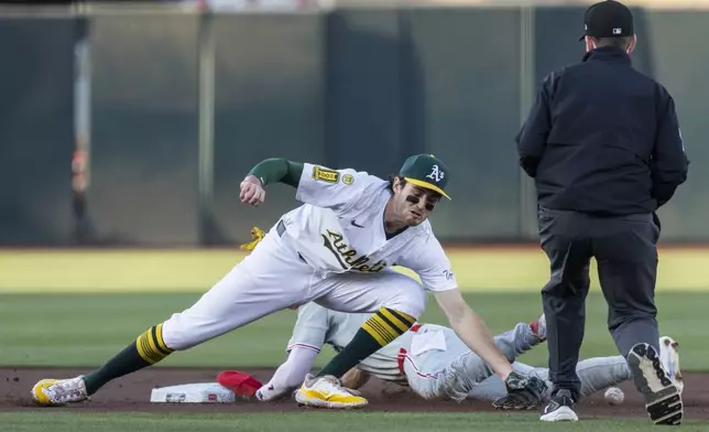 Athletics shortstop Jacob Wilson (5) attempts to tag out Philadelphia Phillies' Trea Turner (7) as he steals second base during the first inning of a baseball game Saturday, May 24, 2025, in West Sacramento, Calif. (AP Photo/Sara Nevis)