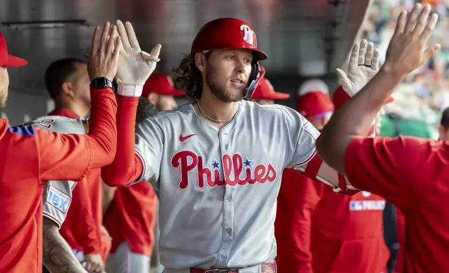 Philadelphia Phillies' Alec Bohm, center, celebrates after hitting a solo home run during the fourth inning of a baseball game against the Athletics, Saturday, May 24, 2025, in West Sacramento, Calif. (AP Photo/Sara Nevis)