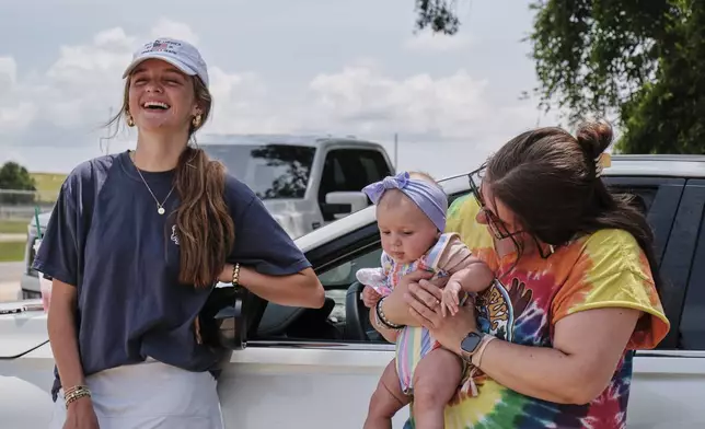 Fans Emma Touchstone, 17, left, and Kelsey Heath with her four-month-old daughter Maggie Fields wait for reality television star Todd Chrisley walks out of the Federal Prison Camp, Wednesday, May 28, 2025, in Pensacola, Fla. (AP Photo/Dan Anderson)