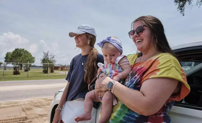 Fans Emma Touchstone, 17, left, and Kelsey Heath with her four-month-old daughter Maggie Fields wait for reality television star Todd Chrisley walks out of the Federal Prison Camp, Wednesday, May 28, 2025, in Pensacola, Fla. (AP Photo/Dan Anderson)