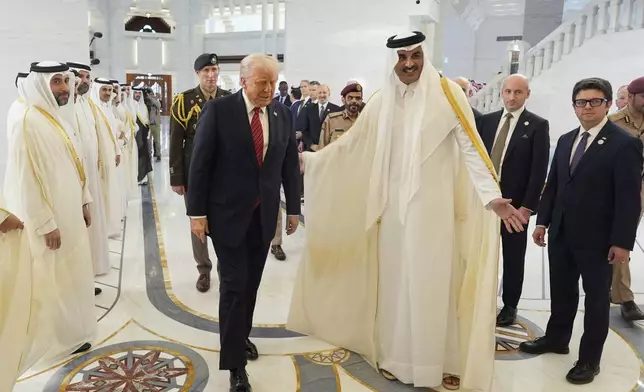 Qatar's Emir Sheikh Tamim bin Hamad Al Thani welcomes President Donald Trump during an official welcoming ceremony at the Amiri Diwan in Doha, Qatar, Wednesday, May 14, 2025. (AP Photo/Alex Brandon)