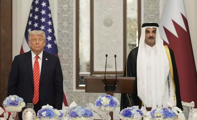 President Donald Trump and Qatar's Emir Sheikh Tamim bin Hamad Al Thani stand during the U.S. national anthem at a state dinner at Lusail Palace in Doha, Qatar, Wednesday, May 14, 2025. (AP Photo/Alex Brandon)