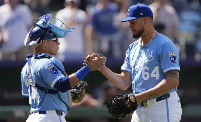 Kansas City Royals catcher Freddy Fermin, left, and relief pitcher Steven Cruz (64) celebrate after their baseball game against the Chicago White Sox, Thursday, May 8, 2025, in Kansas City, Mo. (AP Photo/Charlie Riedel)