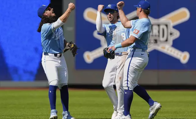 Kansas City Royals outfielders Jonathan India, left, Drew Waters (8) and Hunter Renfroe, right, celebrate after their baseball game against the Chicago White Sox, Thursday, May 8, 2025, in Kansas City, Mo. (AP Photo/Charlie Riedel)