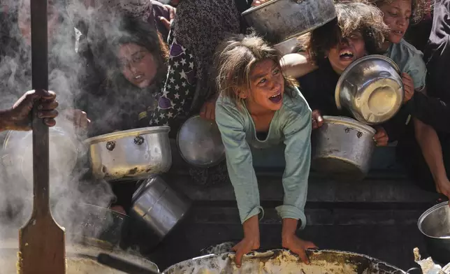 Palestinians struggle to get donated food at a community kitchen in Khan Younis, Gaza Strip, Friday, May 16, 2025. (AP Photo/Abdel Kareem Hana)