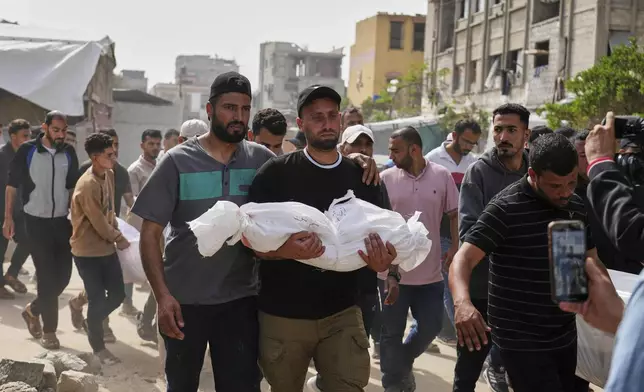 Saleh Zenati, carries the body of his infant nephew Khalid Zenati killed in an Israeli army airstrike, during his funeral in Khan Younis, Gaza Strip, Sunday, May 18, 2025. (AP Photo/Abdel Kareem Hana)