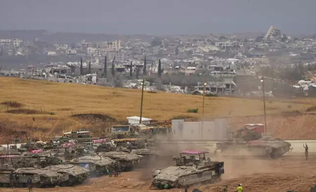 Israeli soldiers work on tanks and APCs at a staging area near the border with the Gaza Strip, in southern Israel, Thursday, May 15, 2025. (AP Photo/Ariel Schalit)