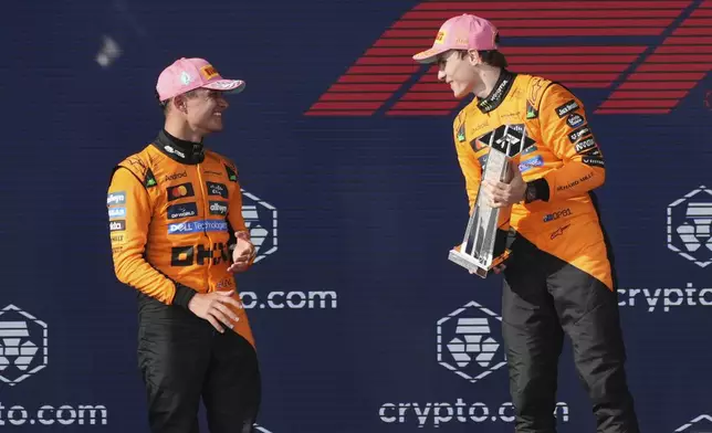 McLaren drivers Lando Norris of Britain, left, and Oscar Piastri of Australia celebrate on the podium after a first and second place finish in the Formula One Miami Grand Prix auto race Sunday, May 4, 2025, in Miami Gardens. Fla. (AP Photo/Marta Lavandier)