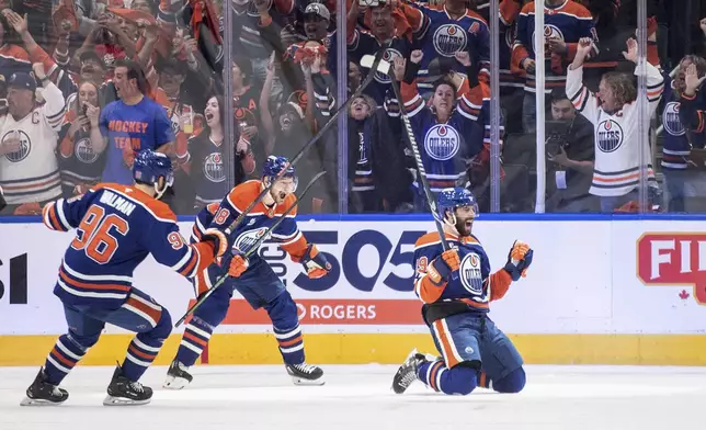 Edmonton Oilers' Adam Henrique (19), Jake Walman (96) and Zach Hyman (18) celebrate after a goal against the Vegas Golden Knights during the first period of Game 4 of a second-round NHL hockey playoff series in Edmonton, Alberta, Monday, May 12, 2025. (Jason Franson/The Canadian Press via AP)