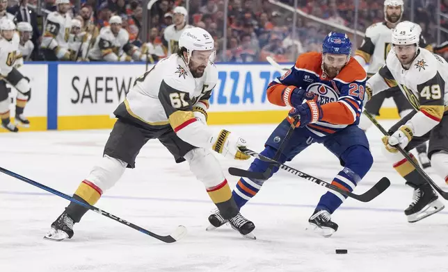 Vegas Golden Knights' Mark Stone (61) and Edmonton Oilers' Leon Draisaitl (29) battle for the puck during the first period of Game 4 of a second-round NHL hockey playoff series in Edmonton, Alberta, Monday, May 12, 2025. (Jason Franson/The Canadian Press via AP)