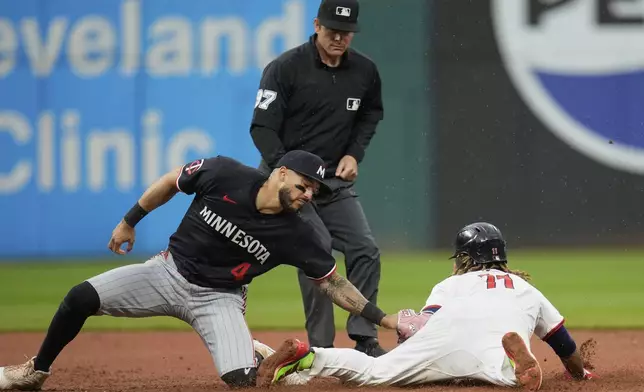 Cleveland Guardians' Jose Ramirez (11) steals second base, his 250th career steal, under the tag of Minnesota Twins shortstop Carlos Correa (4) in the 10th inning of a baseball game in Cleveland, Thursday, May 1, 2025. (AP Photo/Sue Ogrocki)