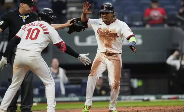 Cleveland Guardians' Jose Ramirez, right, celebrates with teammate Daniel Schneemann (10) after scoring the winning run in the 10th inning of a baseball game against the Minnesota Twins in Cleveland, Thursday, May 1, 2025. (AP Photo/Sue Ogrocki)