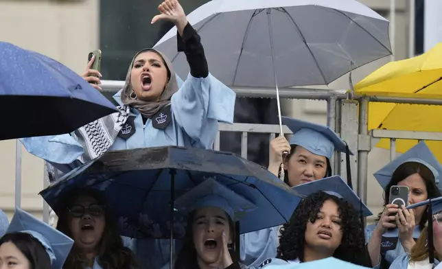 Students react as Columbia University's acting president Claire Shipman speaks during Columbia University commencement ceremony on Columbia's main campus, in Manhattan, on Wednesday, May 21, 2025 in New York. (AP Photo/Seth Wenig, Pool)