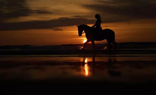 Sandra Hernandez, 23, rides her horse during sunset at Atxabiribil beach in the Penon de Sopelana, northern Spain, Tuesday, May 20, 2025. (AP Photo/Manu Fernandez)