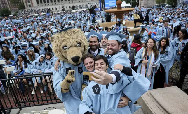 Students pose with a person dressed as Roar-ee the Lion mascot, on the day of Columbia University commencement ceremony on Columbia's main campus, in Manhattan, on Wednesday, May 21, 2025 in New York. (Jeenah Moon/Pool Photo via AP)