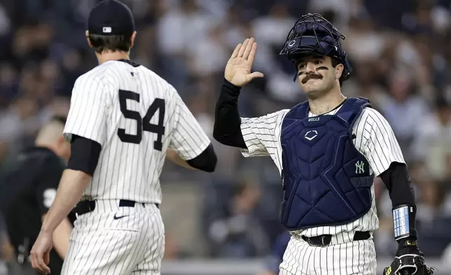 New York Yankees catcher Austin Wells, right, high-fives Max Fried (54) after the last out of the third inning of a baseball game against the Tampa Bay Rays, Friday, May 2, 2025, in New York. (AP Photo/Adam Hunger)